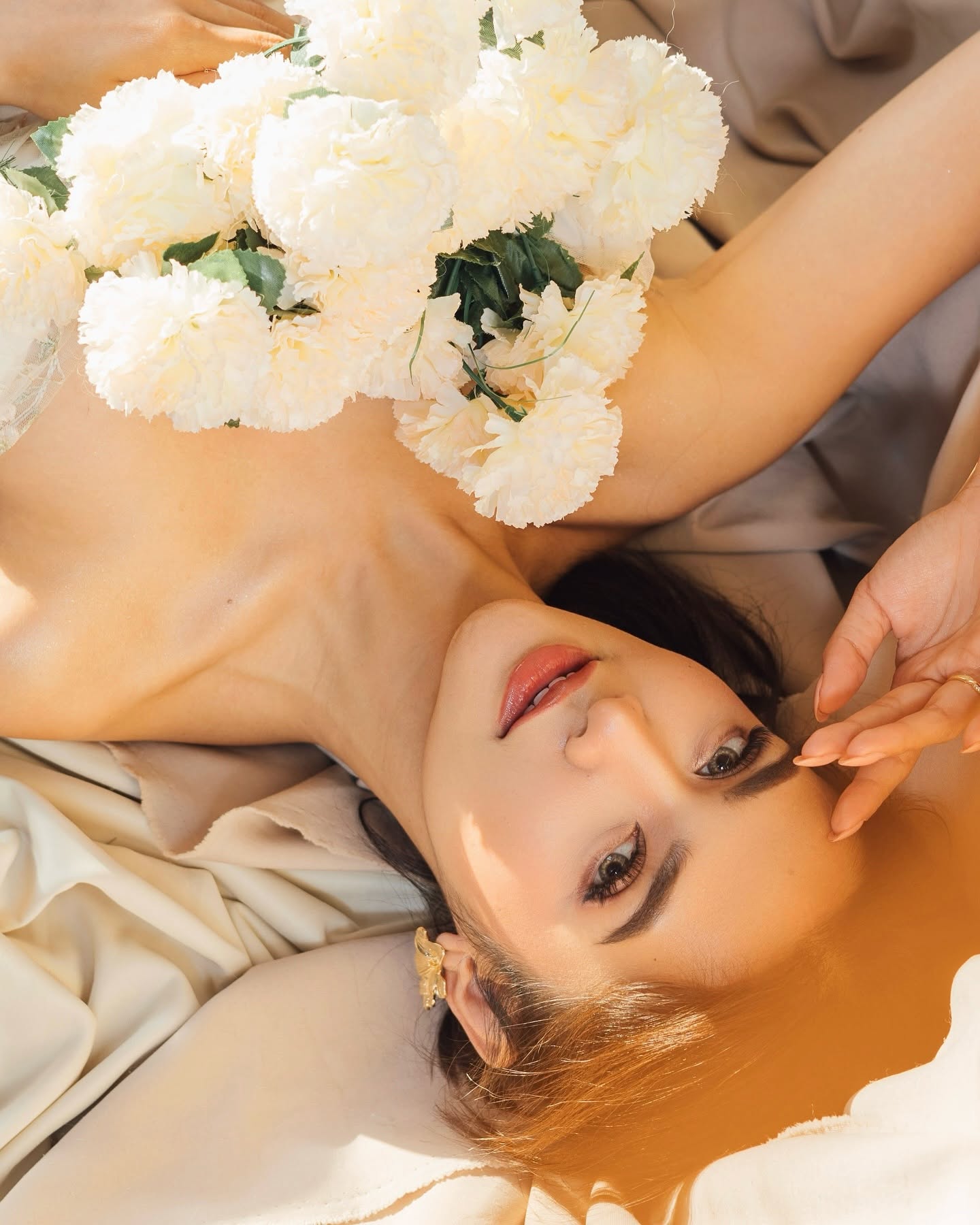 Jacqueline standing by a tall window in soft blush light